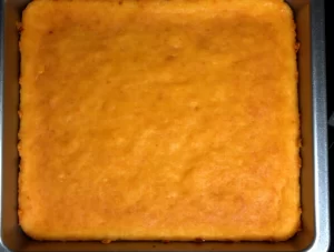 Fatias de bolo de fubá cremoso sendo servidas em um prato, com uma textura cremosa e irresistível.